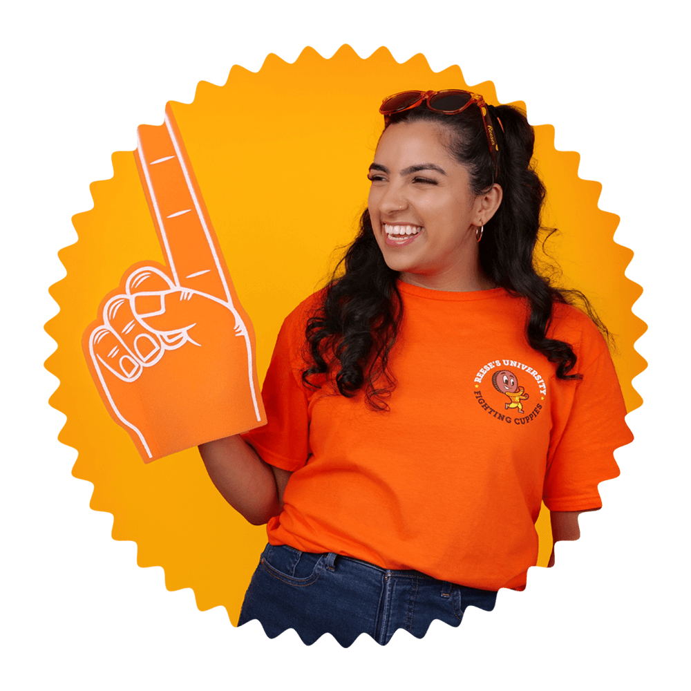 woman wearing reeses university branded clothing raising foam finger into the air
