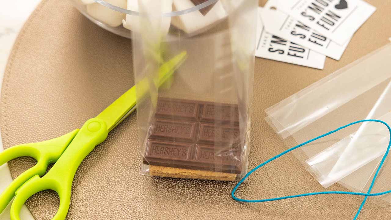 topping the graham crackers in the bag with a half of a milk chocolate bar