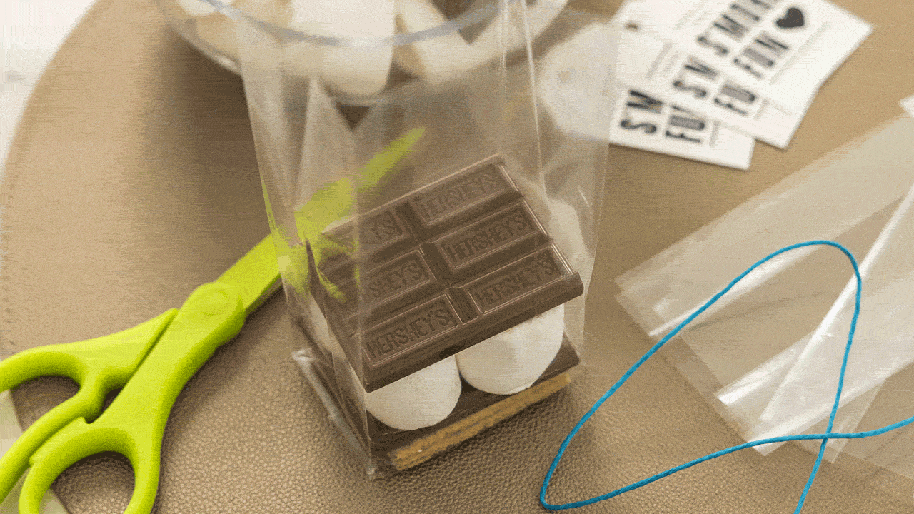 topping the marshmallows with another milk chocolate bar half and graham crackers