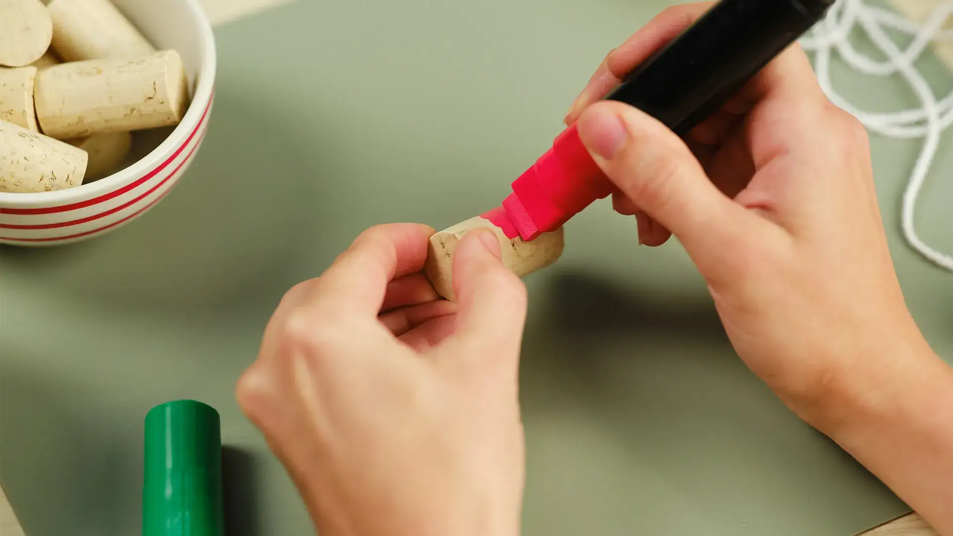 Hands painting a cork
