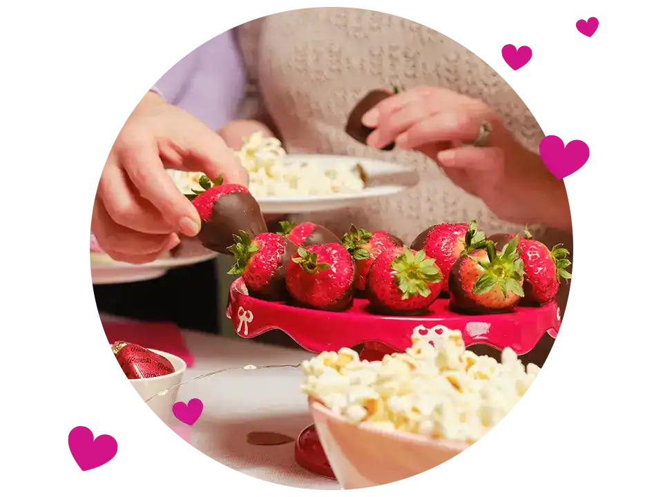 people enjoying chocolate dipped strawberries and salty snacks